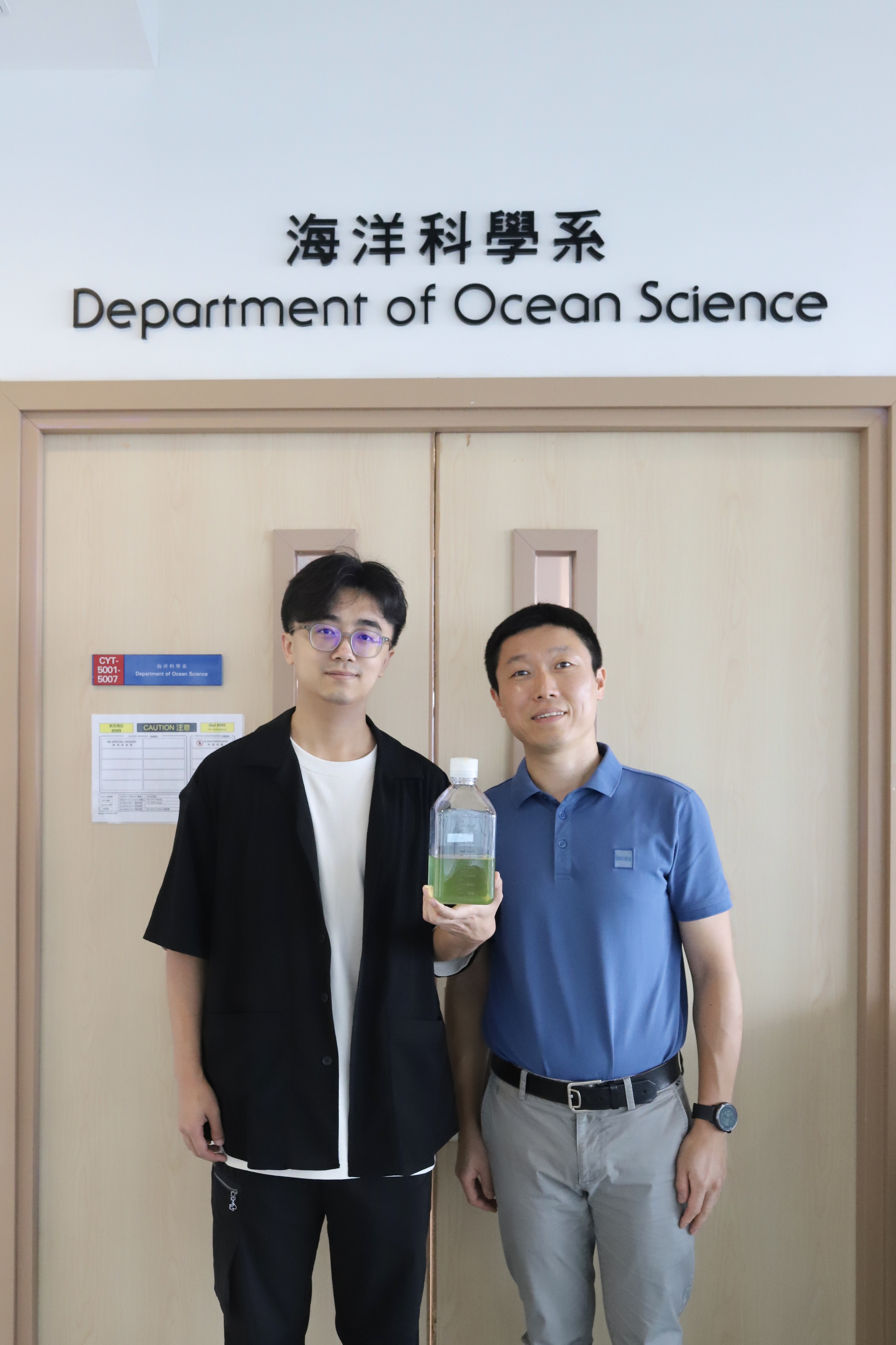 曾慶璐教授（右）及其中一位論文作者科大海洋科學系博士學生栗浩夫（左）展示原綠球藻樣本。