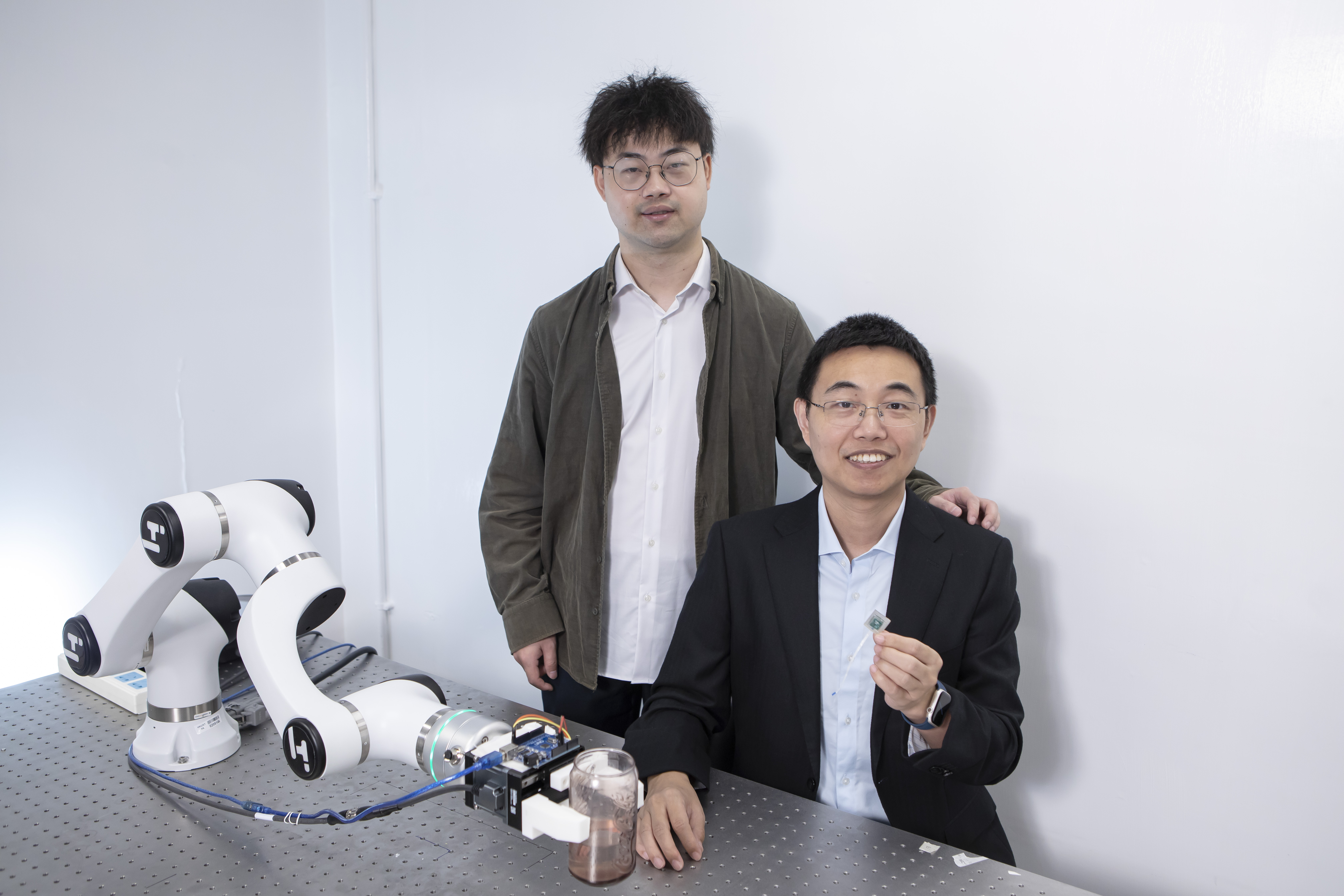 获选首批产学研1+计划的「机器人灵巧操作终端」项目来自香港科技大学工学院研究团队，由电子及计算机工程学系副教授申亚京（右） 率领，研究助理教授杨雄（左）担任负责人。