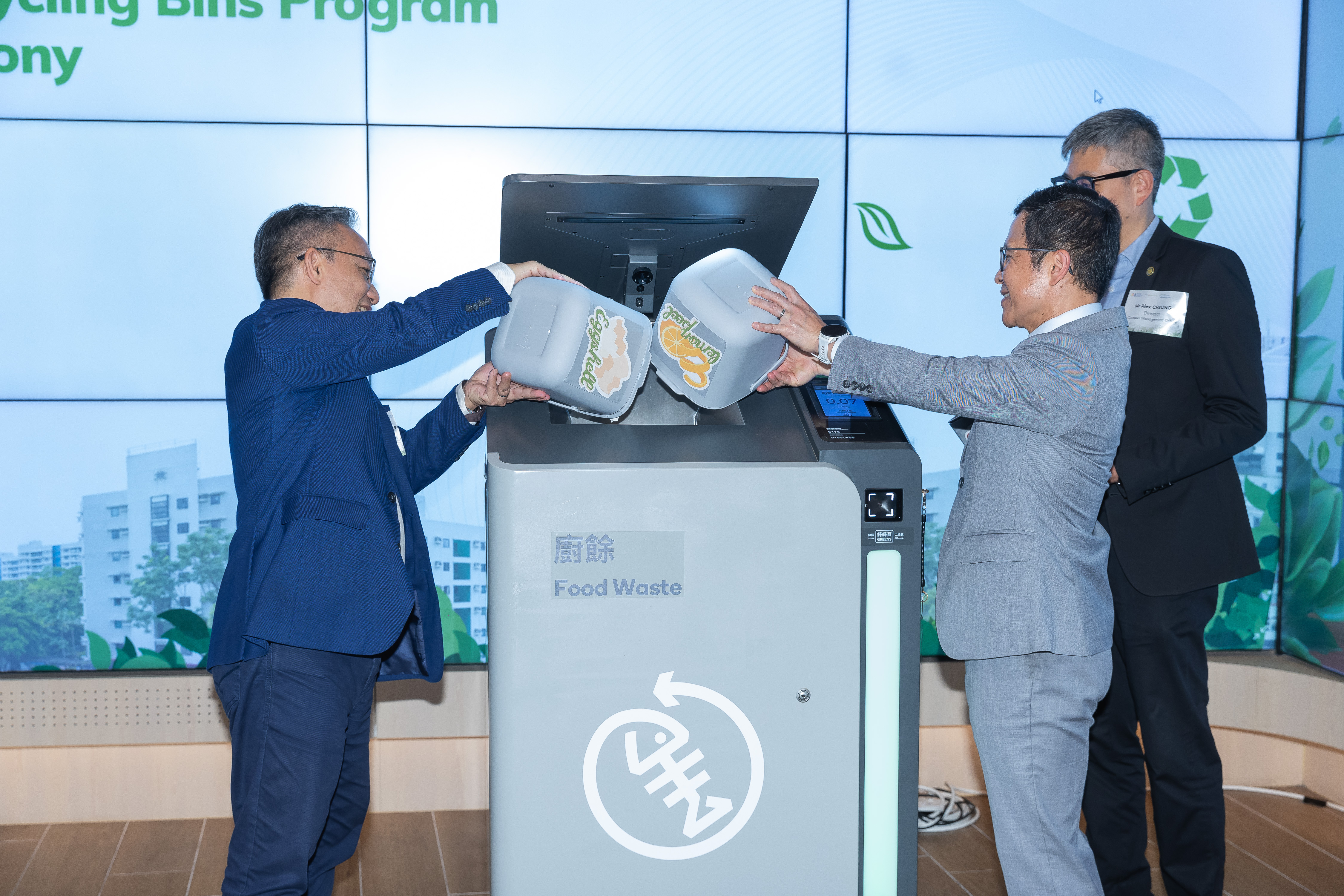 Dr. Leung (left) and Mr. Cheng (right) demonstrate how to operate the smart recycling bin