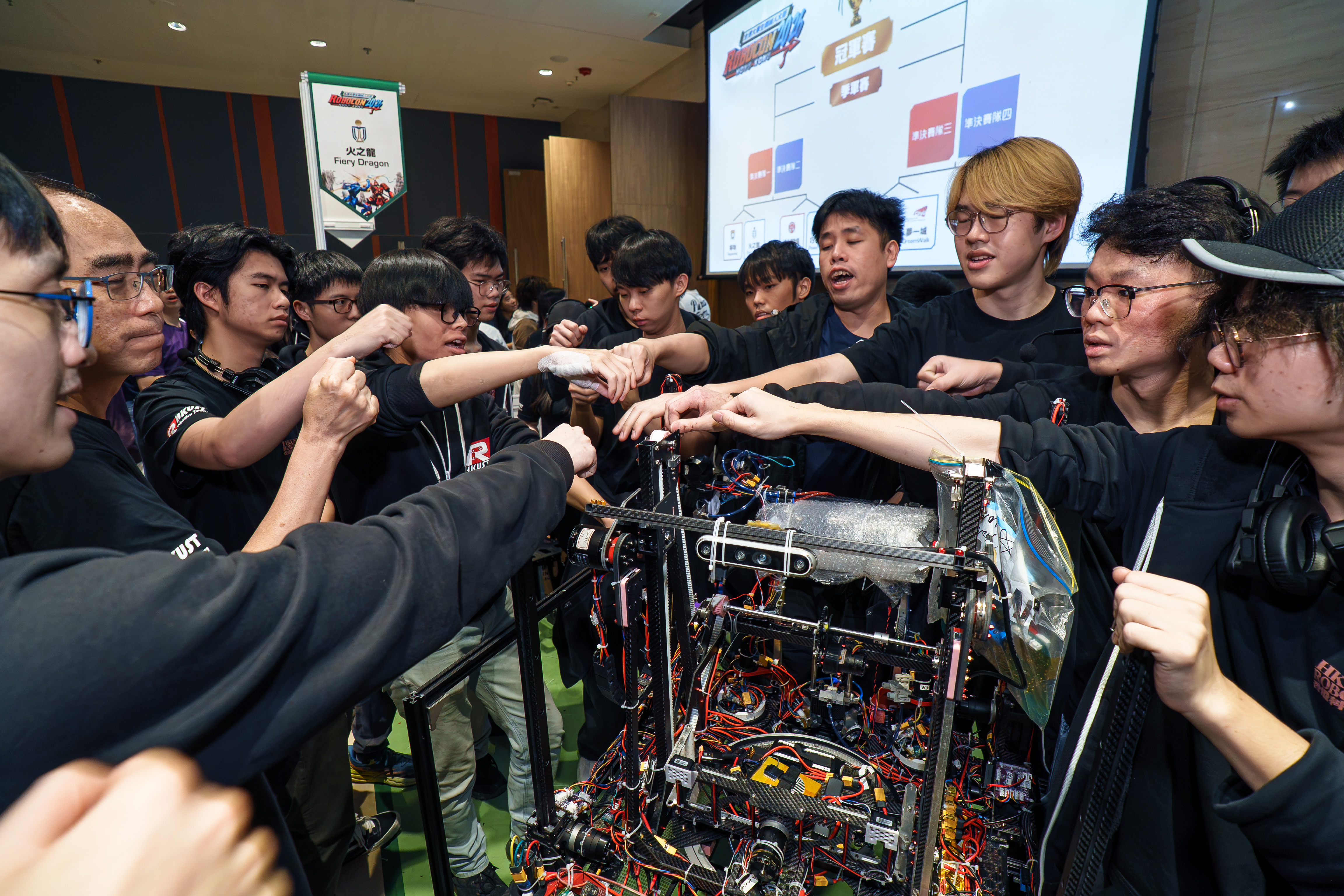 The teams gather for a pre-match huddle, locking in their focus after weeks of relentless, late-night build sessions.