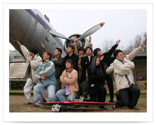 Dajung Kim posing with classmates in front of an aircraft