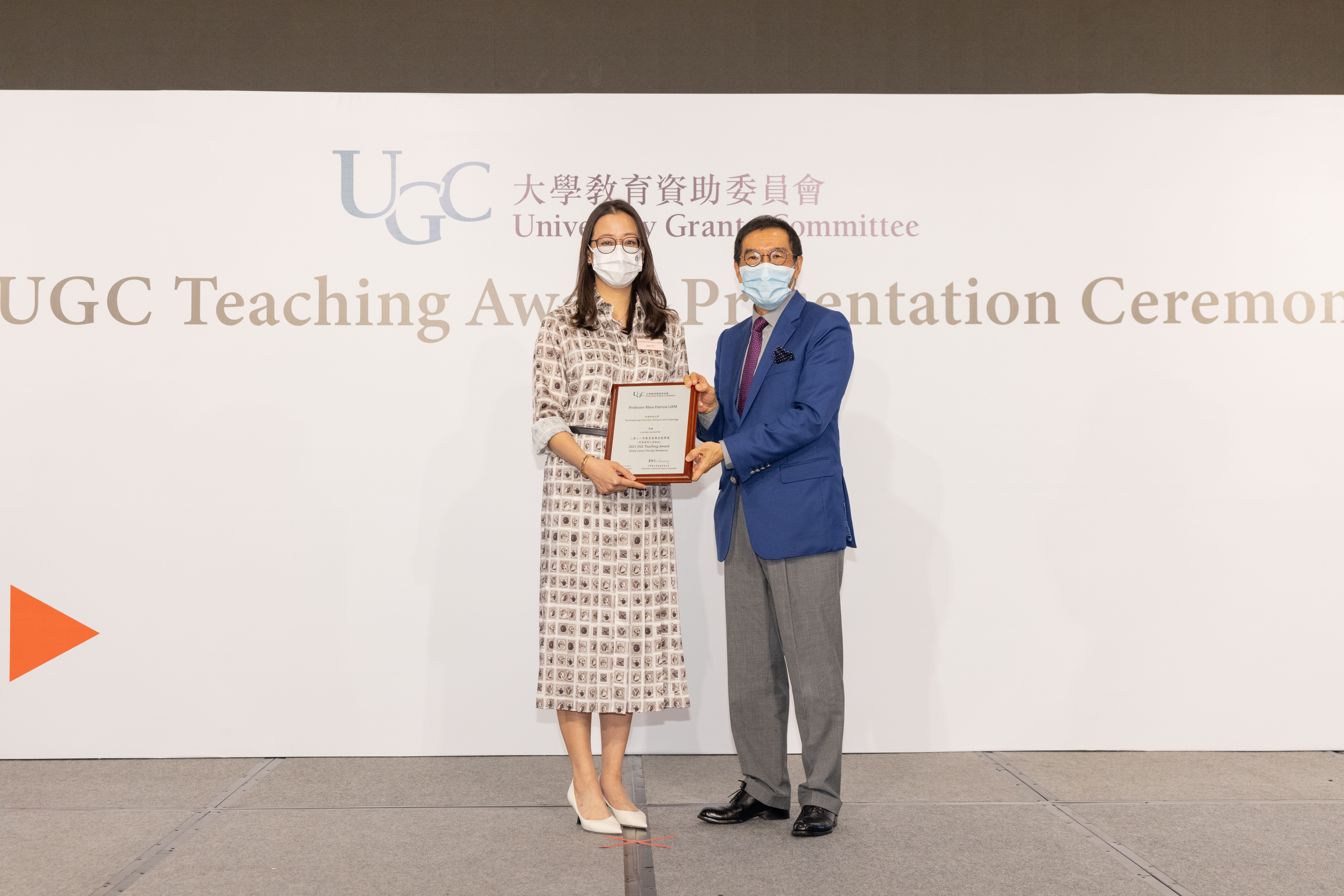 Chairman of the University Grants Committee (right) Mr. Carlson TONG (position) presents the 2021 UGC Teaching Award for Early Career Faculty Members to Prof. Rhea LIEM.