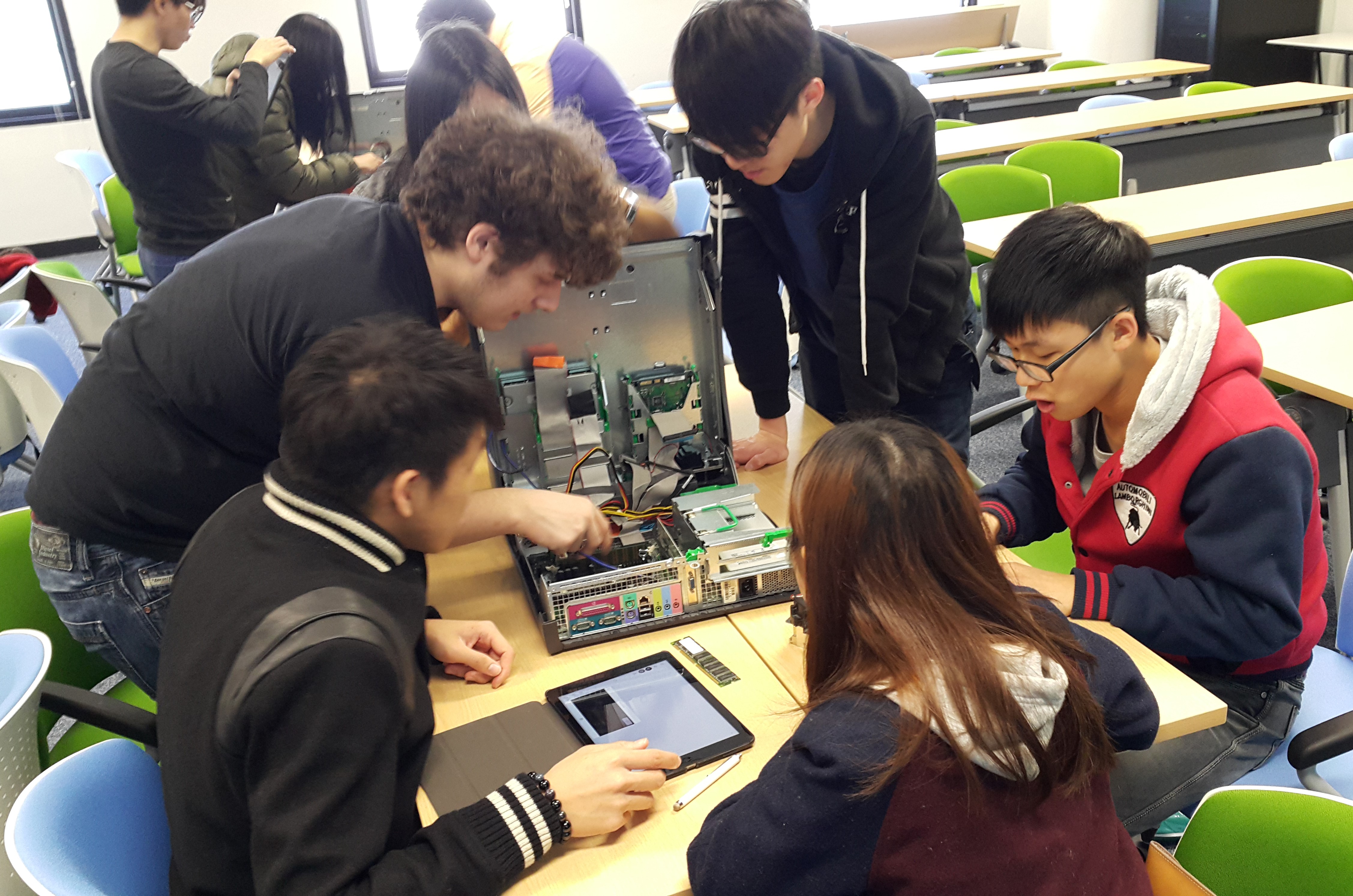 Students work in teams to identify hardware components inside a desktop computer