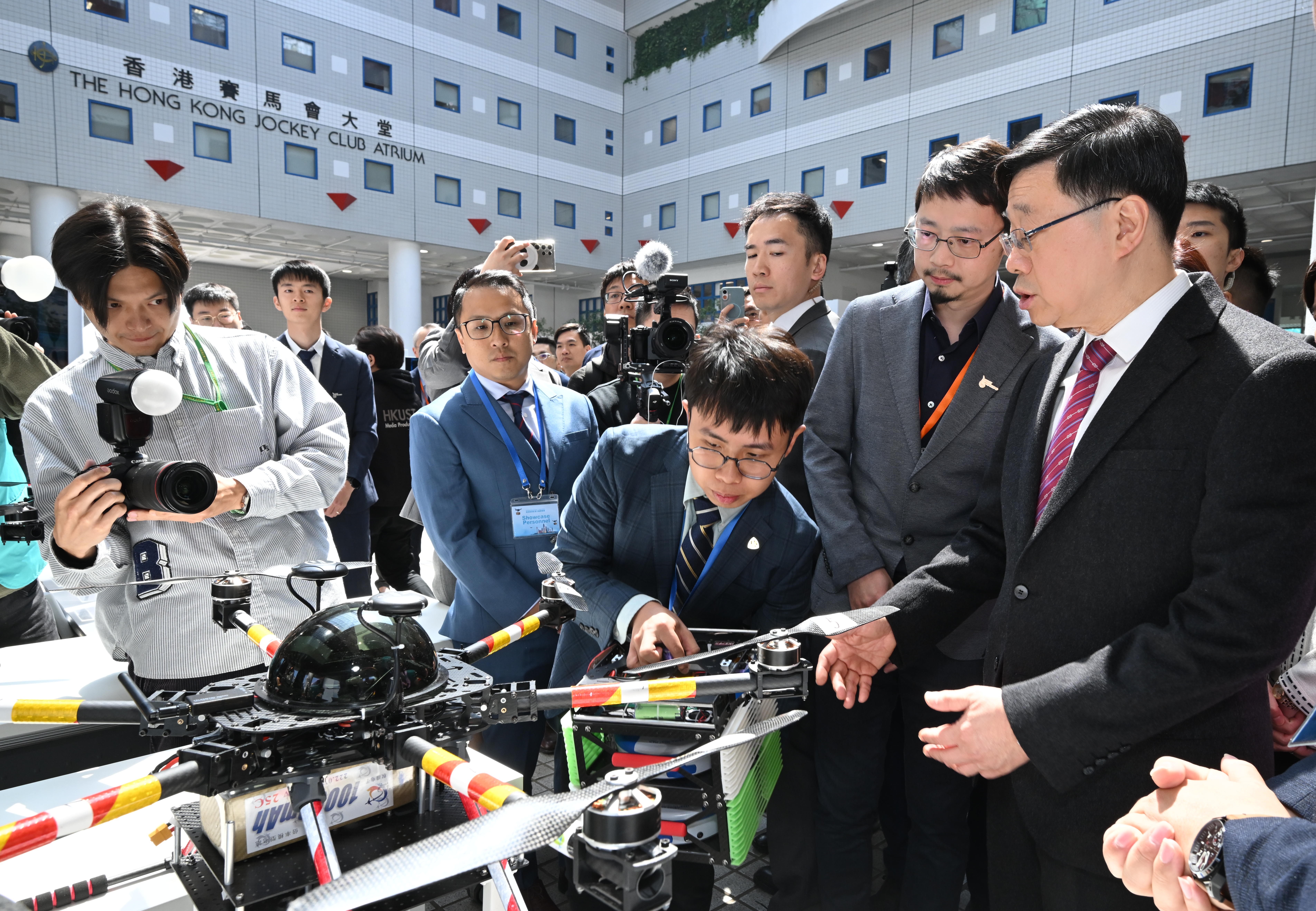 Director of HKUST Low Altitude Economy Research Center (LAERC) Prof. LI Mo (second right) and his research team member: Integrative Systems and Design student WU Chun-Ming (third right), introduce the Center’s UAV-Based Emergency Rescue Regulatory Sandbox pilot project to Mr. Lee (first right).