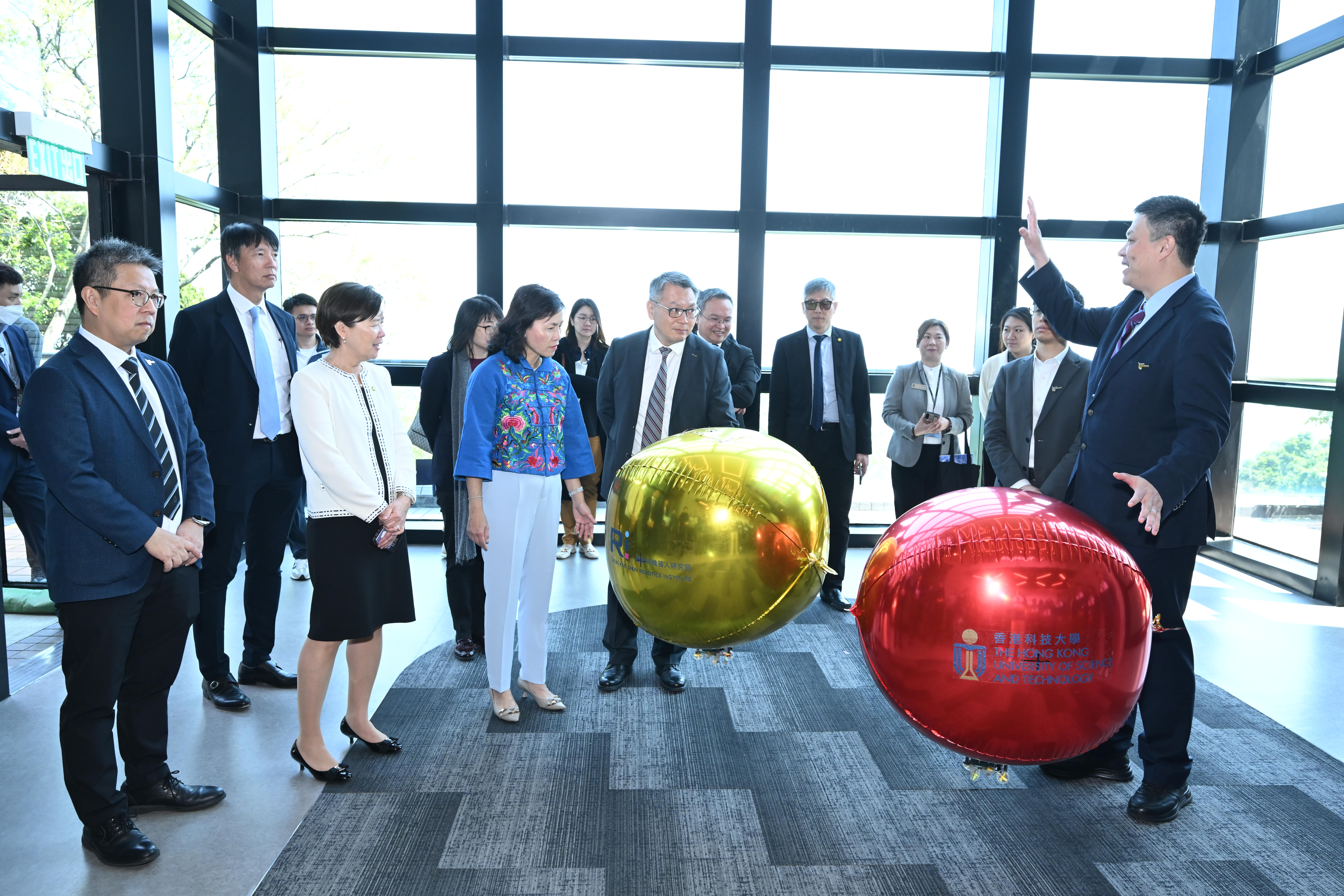 Prof. ZHANG Fumin, Director of Cheng Kar-Shun Robotics Institute (first right), displays this miniature autonomous blimp that can fly closely to the public in a safe manner.