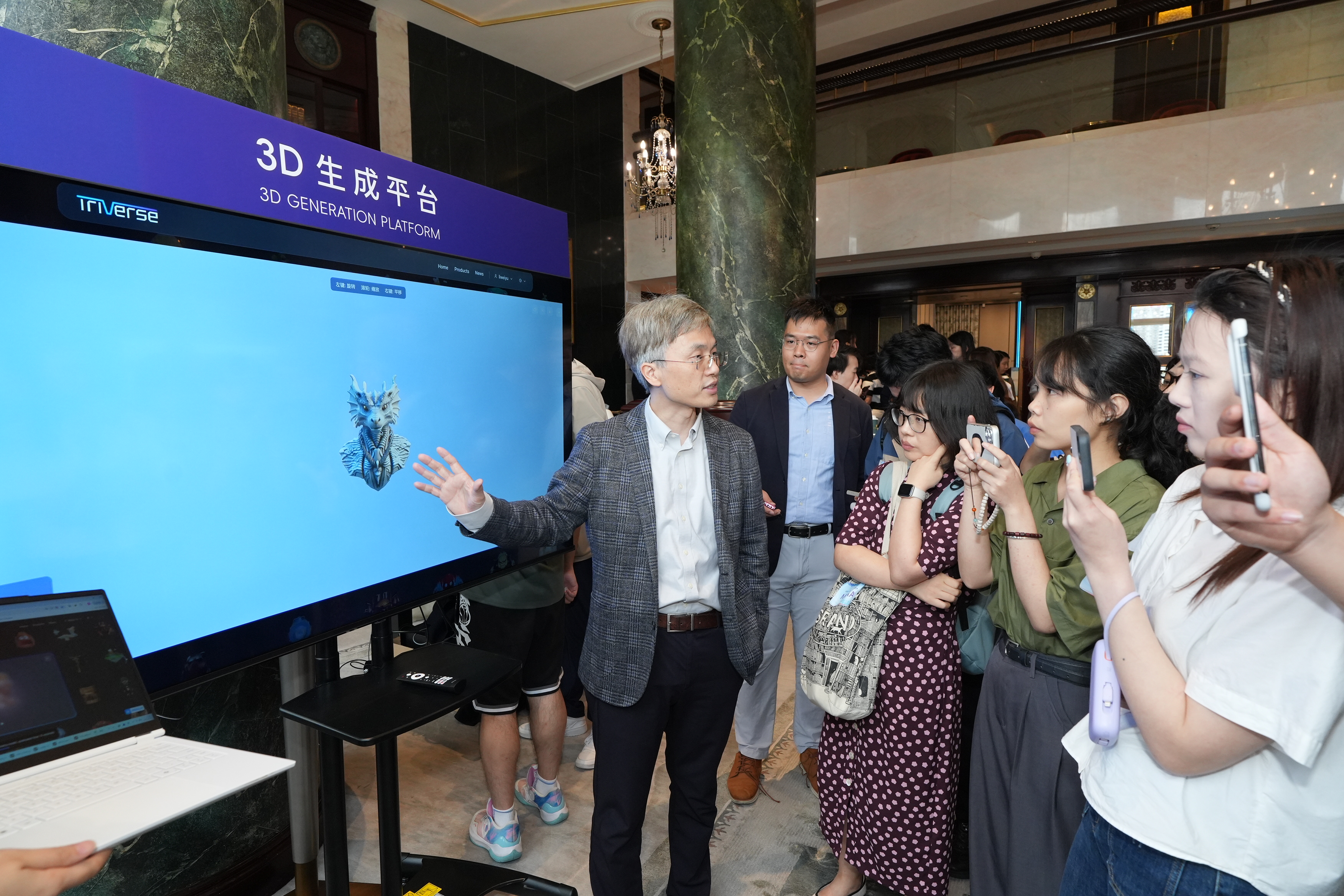 谭平教授（左一）简介其开发的3D生成平台。该平台目前已开放予公众于triverse.ai网站试用。
