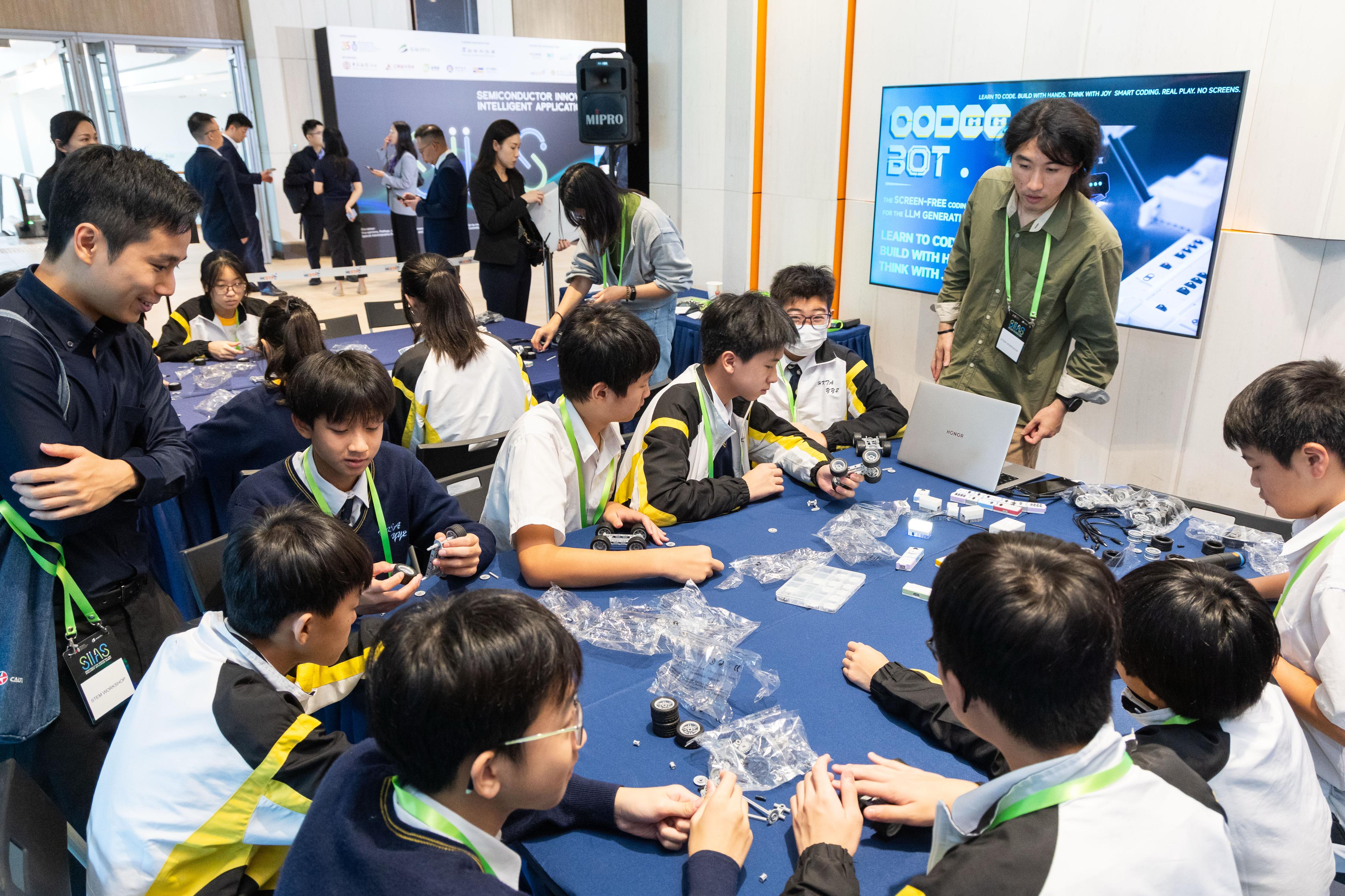 Over 100 students participated in immersive activities, including exploring exhibition booths to learn how semiconductors enhance quality of life and engaging in hands-on experimentation with AI applications in coding design.