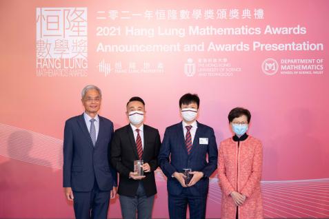 Group picture of The Hon. Mrs. Carrie LAM CHENG Yuet-ngor (first right) and Prof. Wei SHYY, President, HKUST (first left), with Principal Mr. Lik Ko HO (second left) and Teacher Mr. Ho Fung LEE (second right) of Pui Ching Middle School.  Gold Award winner Tsz Hin CHAN, though out of town, is present online at the ceremony and shares his thoughts on winning. 