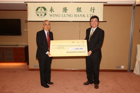 永 隆 银 行 慈 善 基 金 主 席 伍 步 高 博 士 (左) 赠 交 支 票 给 科 大 首 席 副 校 长 钱 大 康 教 授 。	