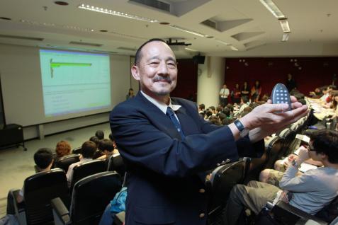 Prof Nelson Cue, who invented the Personal Response System (PRS), displays the remote-control handset in a lecture theater where the PRS is being used.	