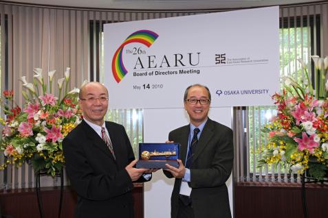 President Chan (right) presents to President Washida of Osaka University a golden key souvenir featuring Hong Kong’s landmarks, including the sundial at the HKUST entrance.	