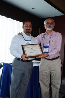  Professor Mukhopadhyay (left) receives the award from Professor Rajeev Batra, Chair of the SCP’s Scientific Affairs Committee and the Sebastian S. Kresge Professor of Marketing at the University of Michigan.