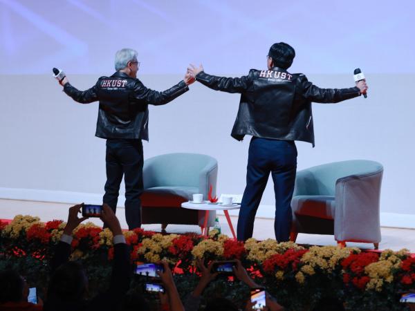 Prof. Shum (left) and Dr. Huang present to the audience their stylish black leather jackets emblazoned with “HKUST”