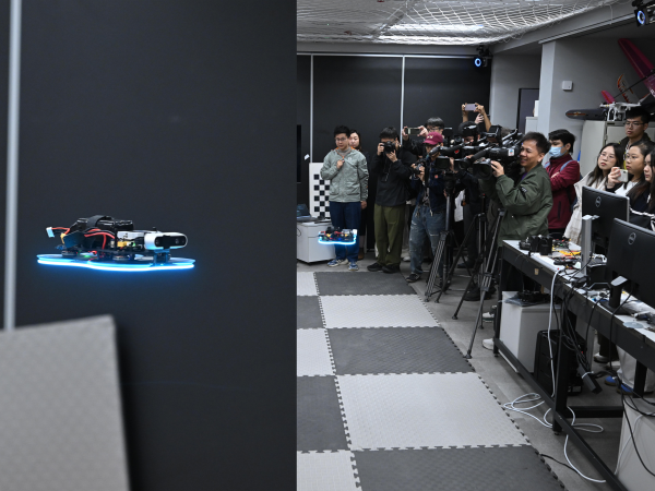 Prof. Zhang Fumin (third right) and his team demonstrate in the HKUST Cheng Kar-Shun Robotics Institute (CKSRI) how the drone installed with sensors developed by HKUST autonomously navigates around complex environment. 