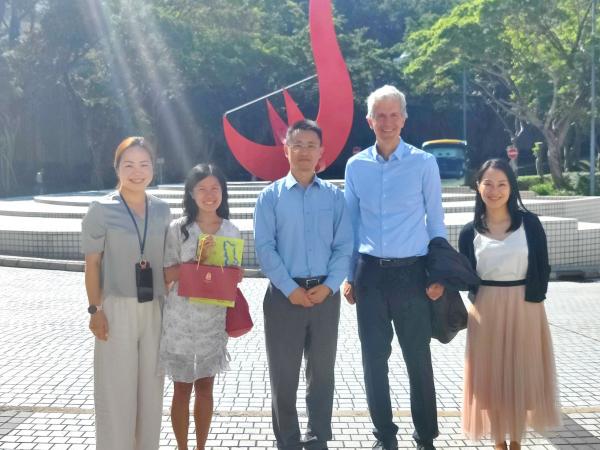 A group photo of Consul General Stefan BREDOHL (second right) and the HKUST team in front of the iconic “Red Bird” sculpture at the Piazza.