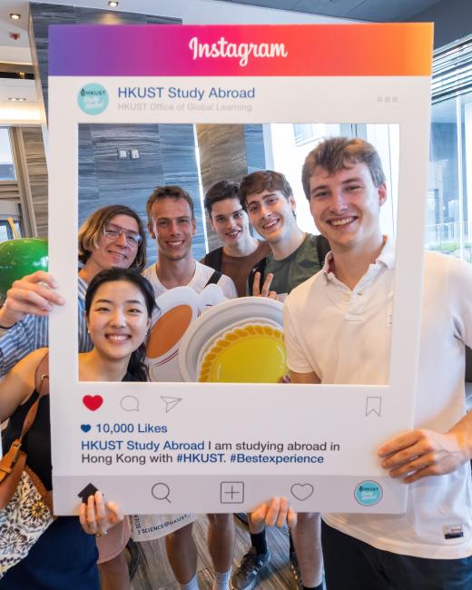 International students inside a cardboard cutout of an Instagram post