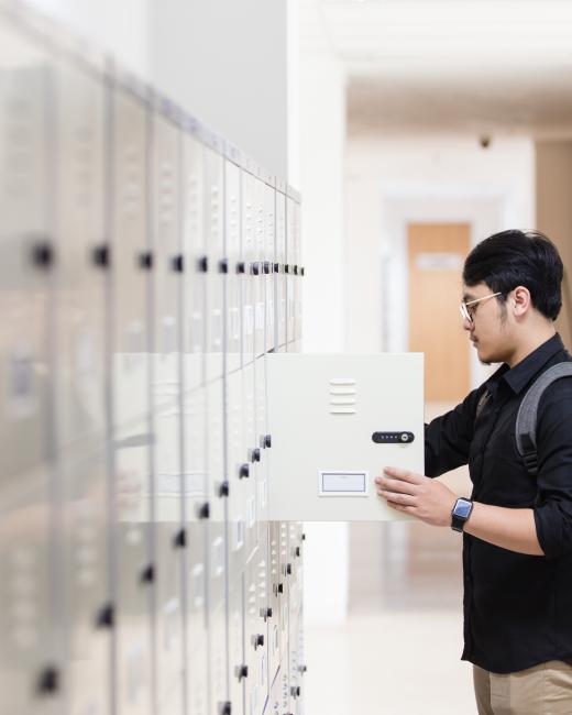 University student putting things in his locker