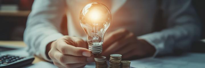 man holding a lighted lightbulb